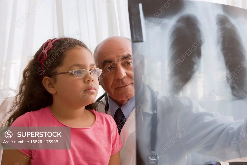 Hispanic doctor showing chest x-rays to patient