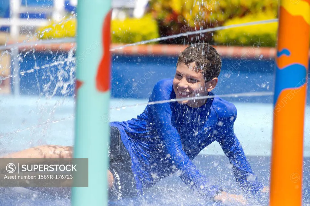 Hispanic boy playing at water park