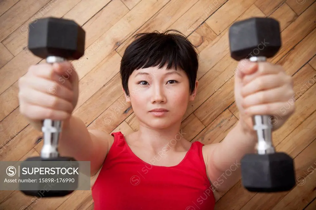 Woman lifting weights on floor