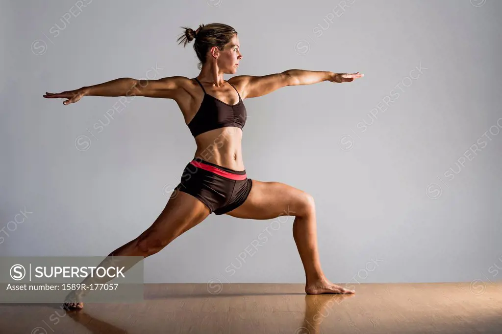 Caucasian woman practicing yoga in studio