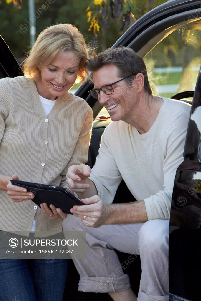 Caucasian couple using digital tablet in car