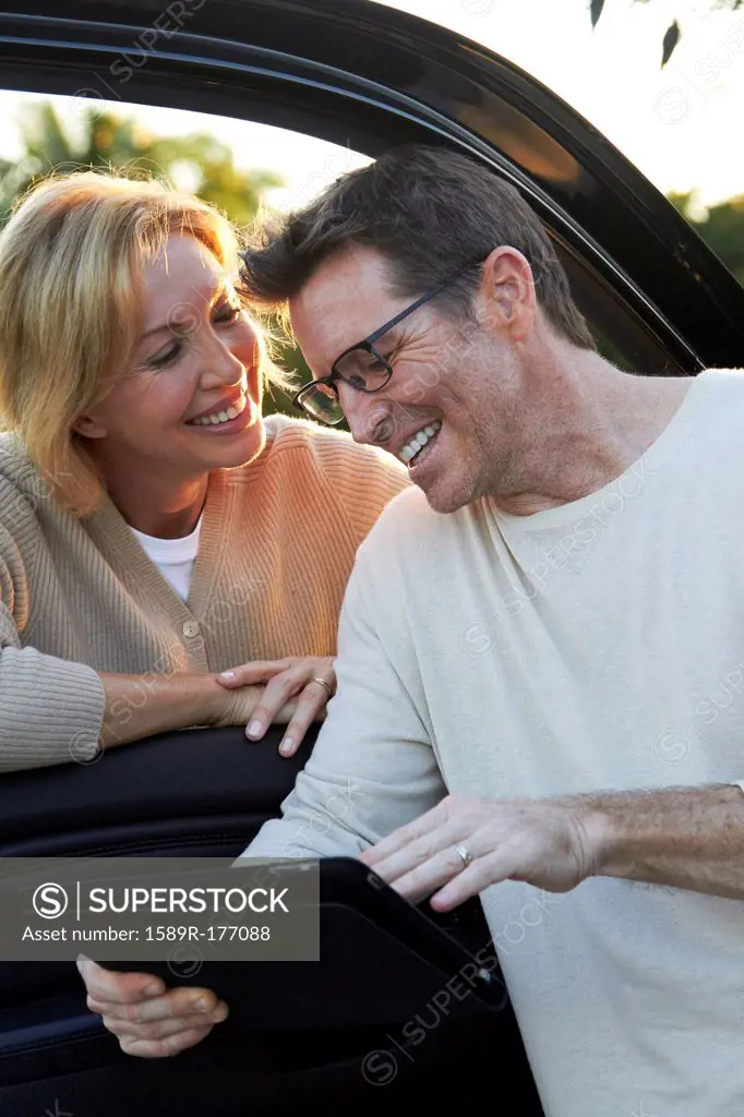 Caucasian couple using digital tablet by car