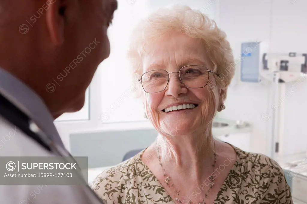 Hispanic doctor talking with older patient