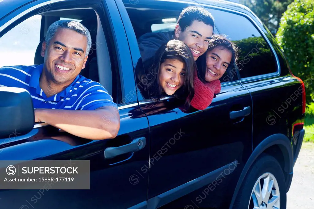 Hispanic family smiling in car