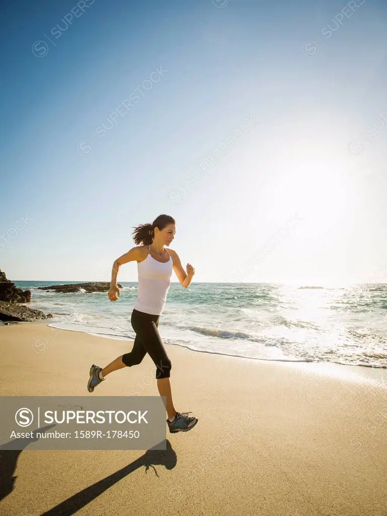 Mixed race woman running on beach