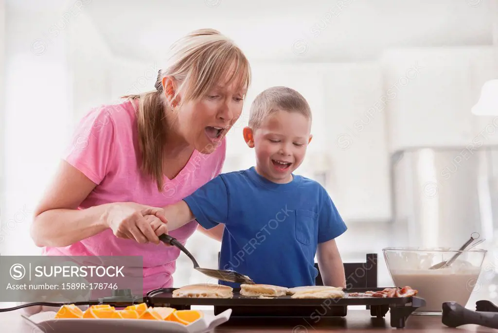Caucasian mother and son cooking breakfast
