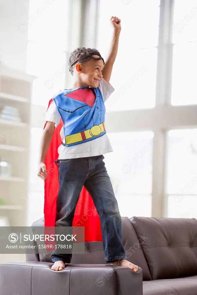 Mixed race boy playing superhero