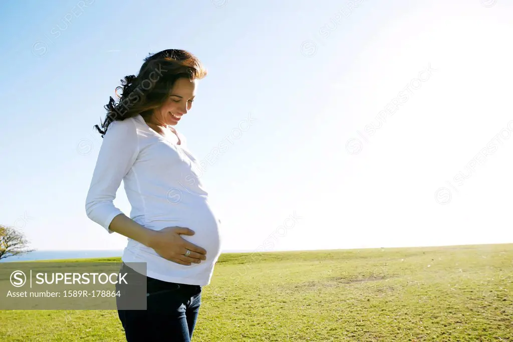 Pregnant mixed race woman holding her belly