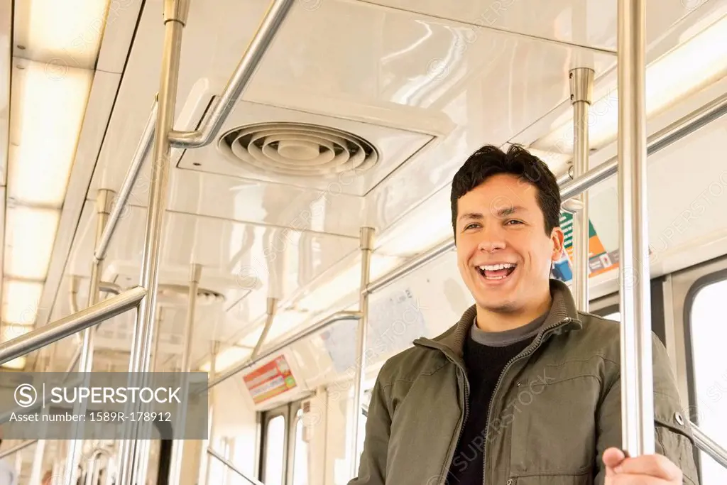 Hispanic man laughing on train