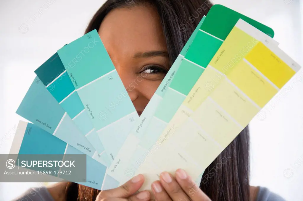 Mixed race woman holding paint swatches