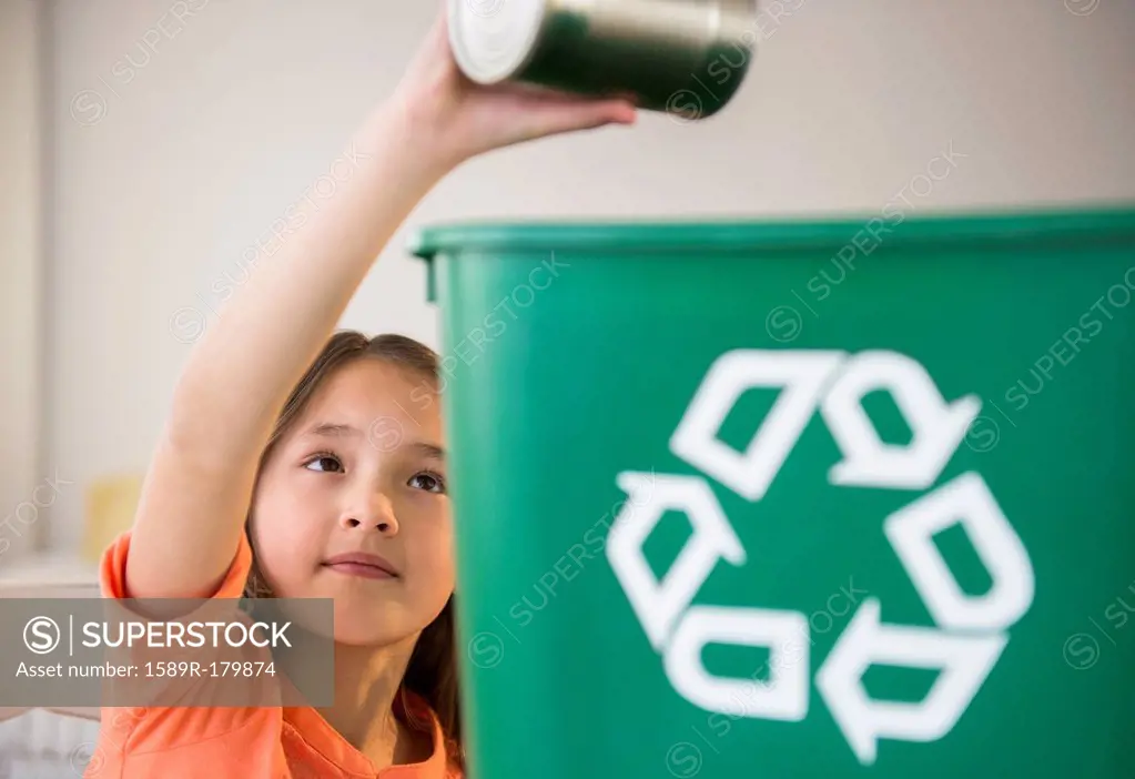 Mixed race girl recycling can
