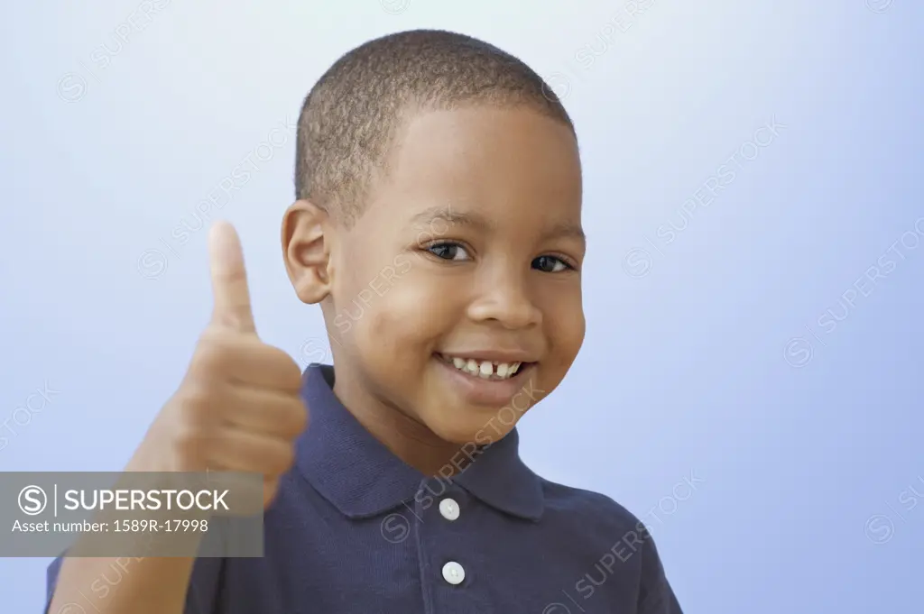 Close up of African American boy giving thumbs up