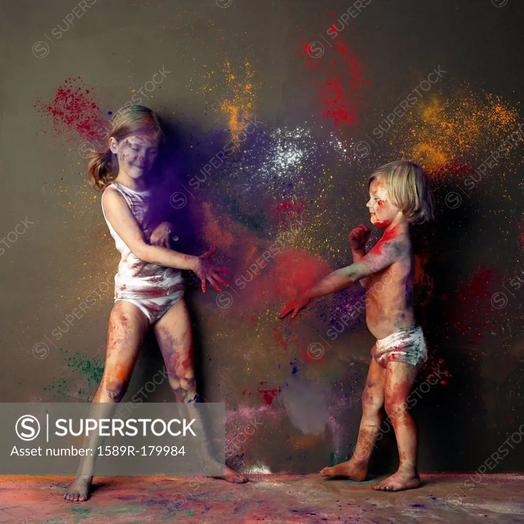 Caucasian children playing with paint