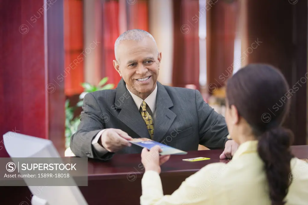 Businessman receiving brochure from a receptionist