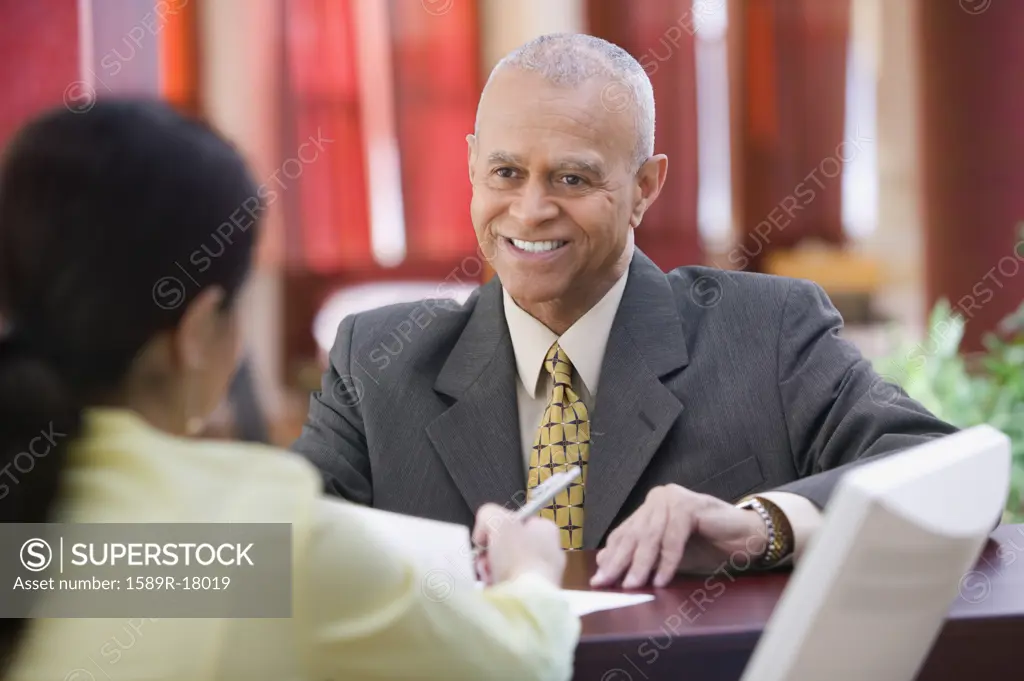 Businessman smiling at receptionist