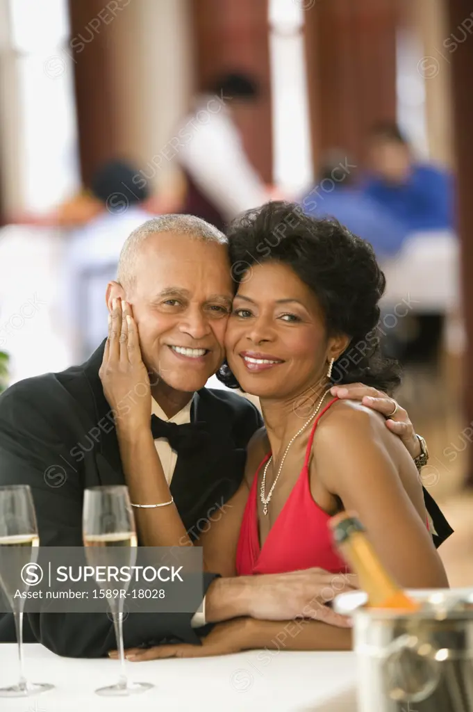 Couple smiling for the camera at dinner table