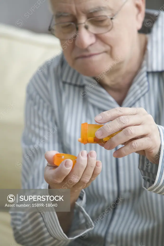 Older man shaking out pills into his hand