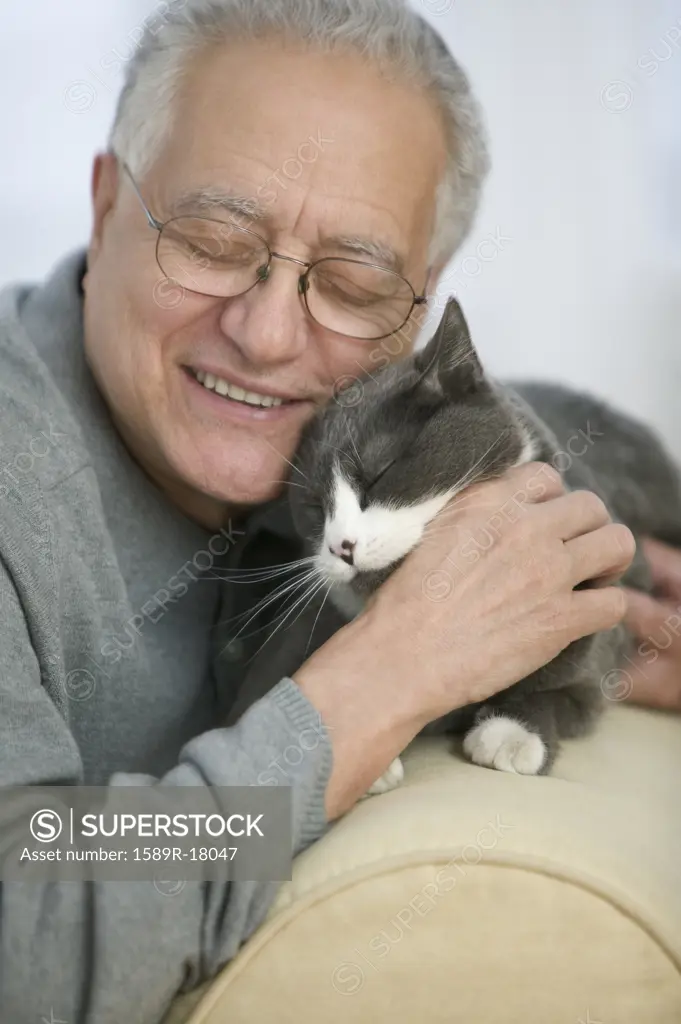 Older man nuzzling his cat
