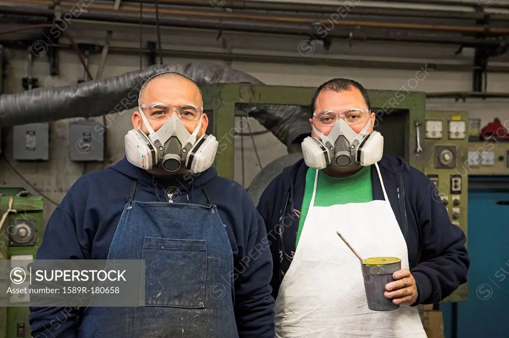 Hispanic workers wearing gas masks in textile factory