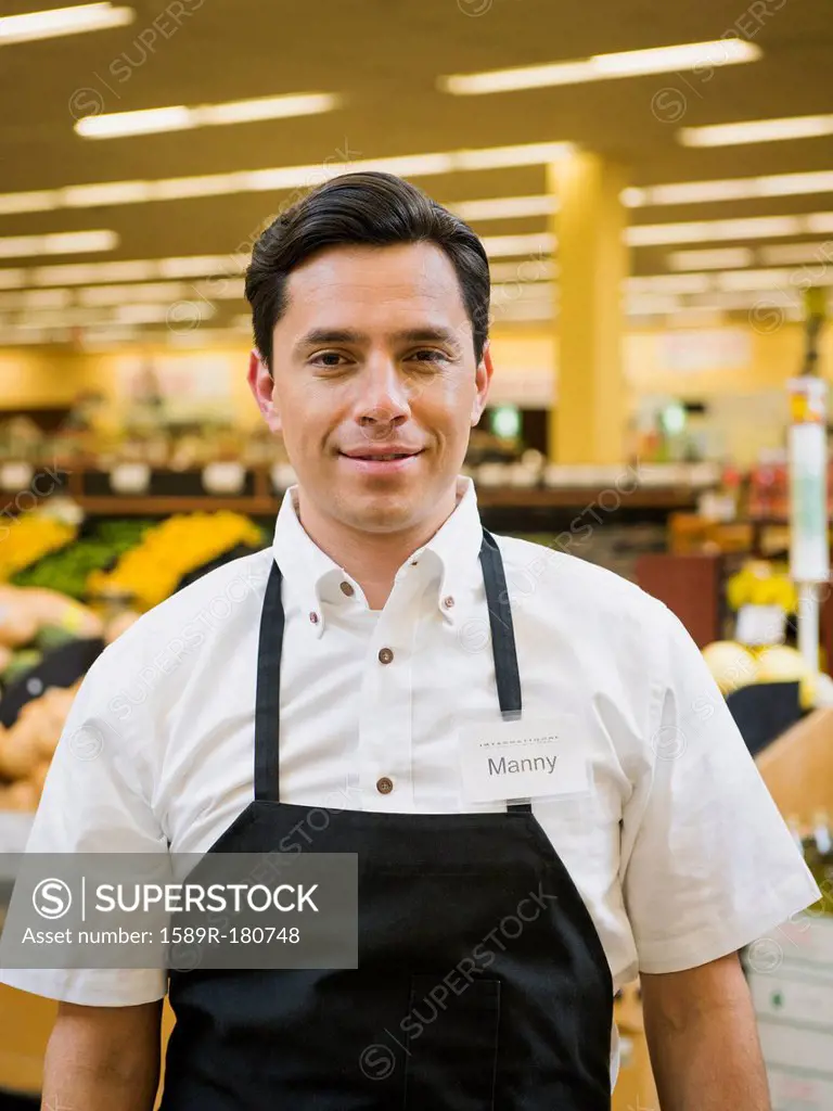 Hispanic worker smiling in grocery store