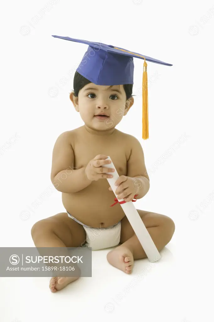 Toddler boy in diaper with mortar board and diploma