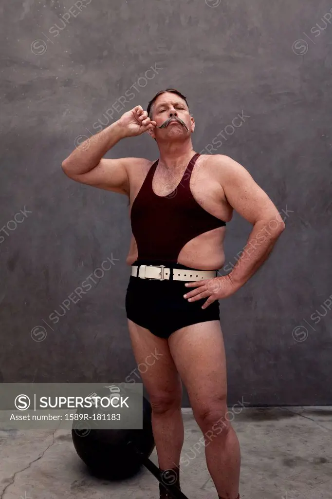 Caucasian weight lifter twirling his mustache
