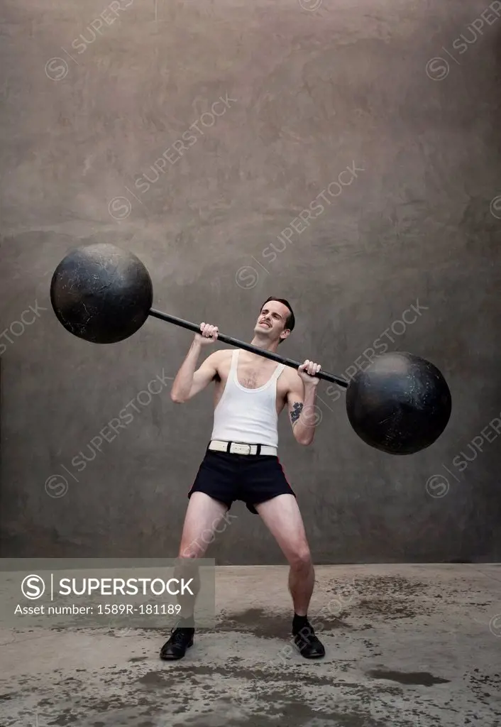 Skinny Caucasian weight lifter straining