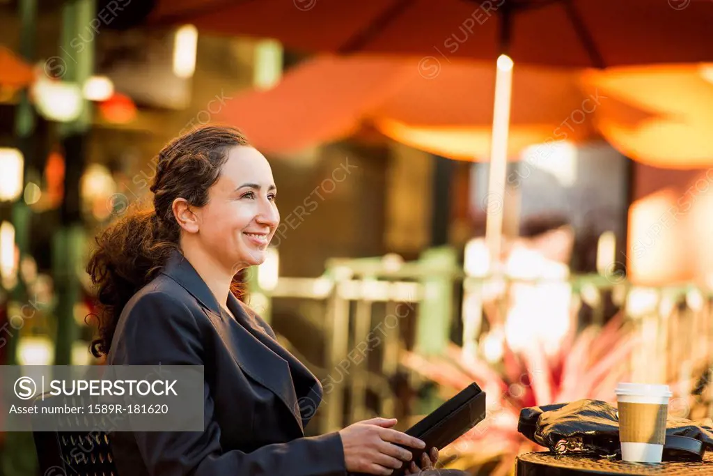 Hispanic businesswoman working at cafe