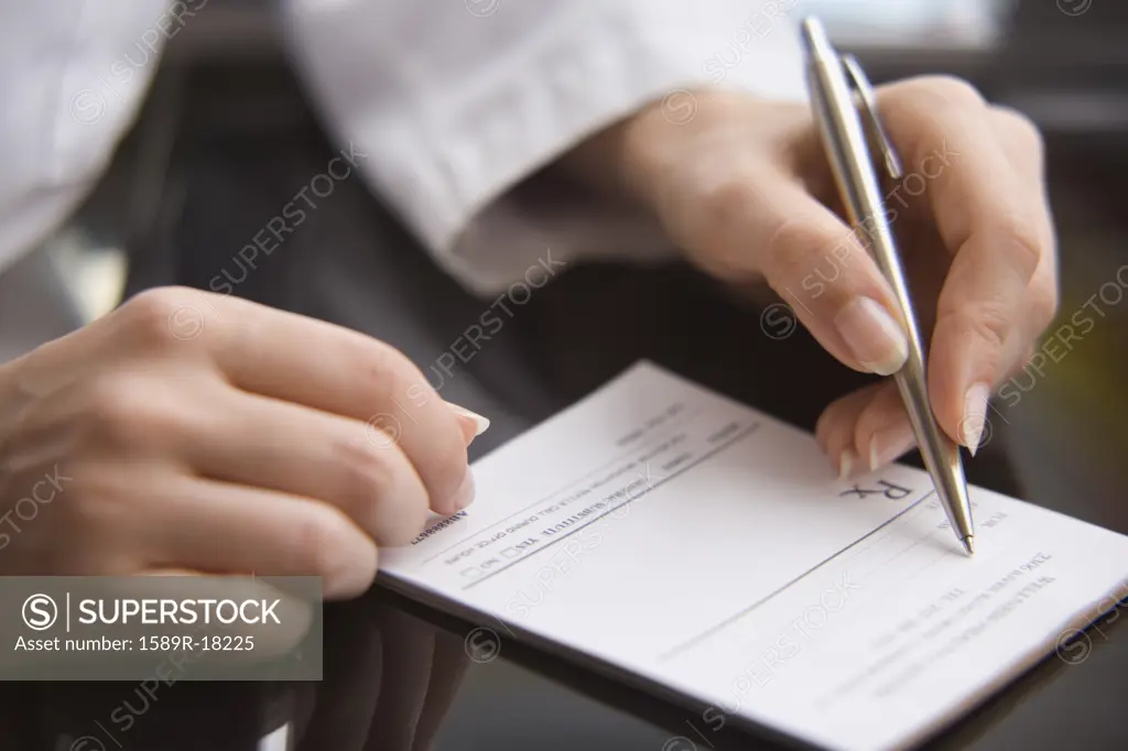 Close up of female doctorís hands writing prescription