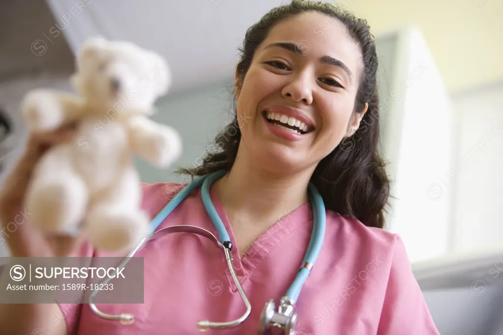 Portrait of female nurse with teddy bear