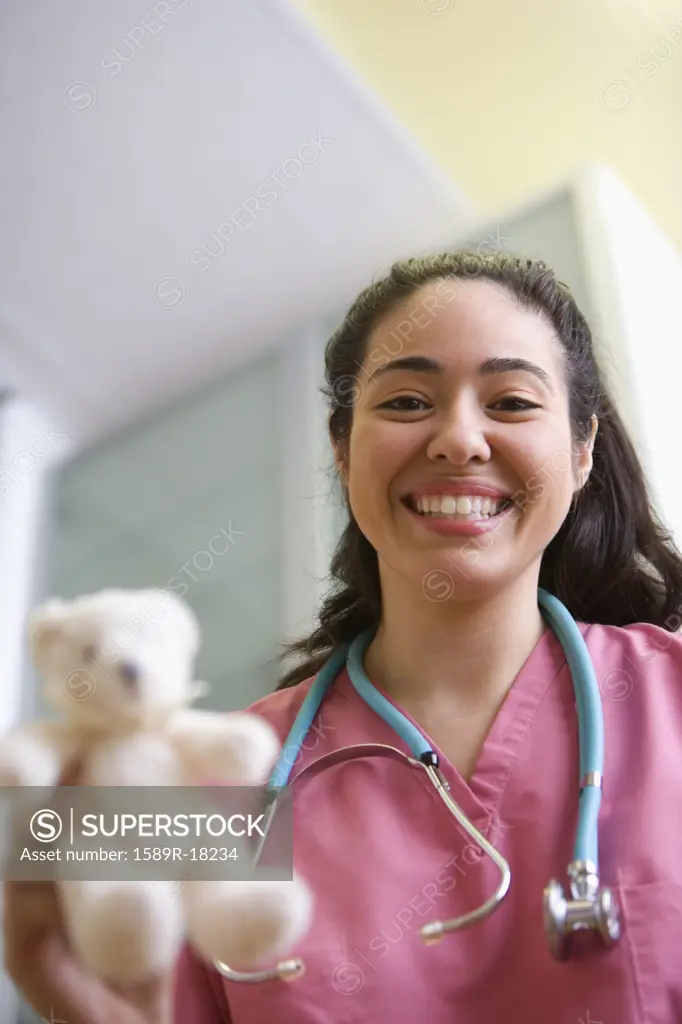Portrait of female nurse with teddy bear