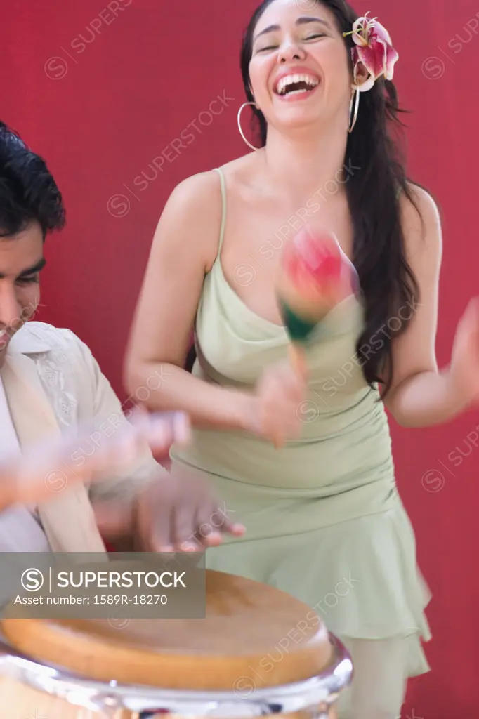 Woman dancing while man plays conga