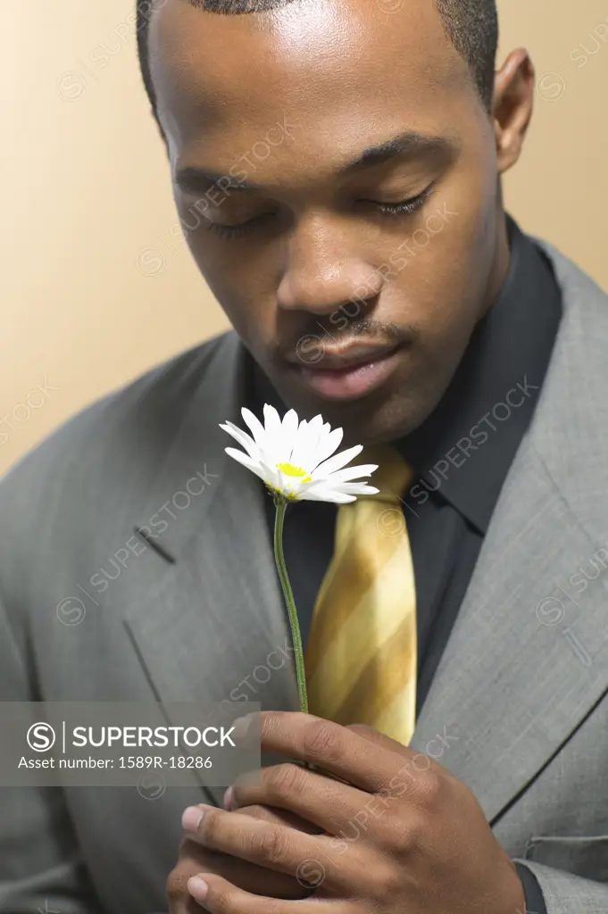 Man in suit holding daisy