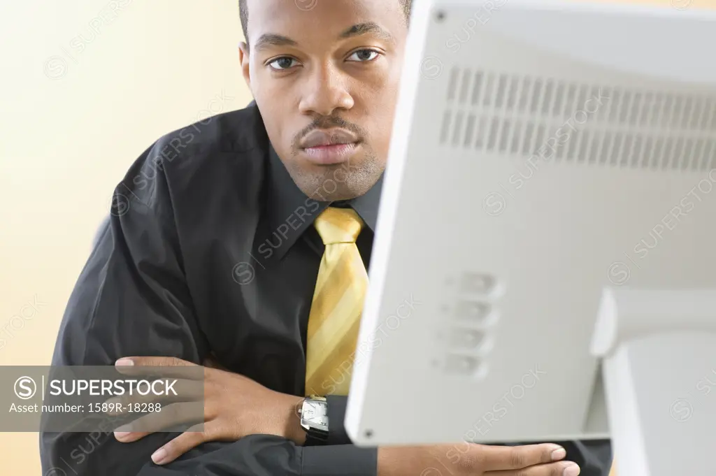 Portrait of businessman sitting at desk in front of computer
