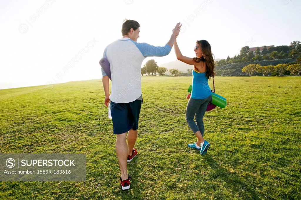 Couple high fiving in park