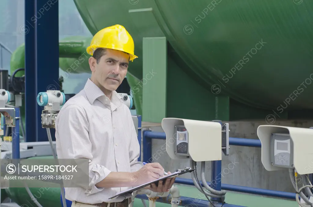 Hispanic worker checking machinery