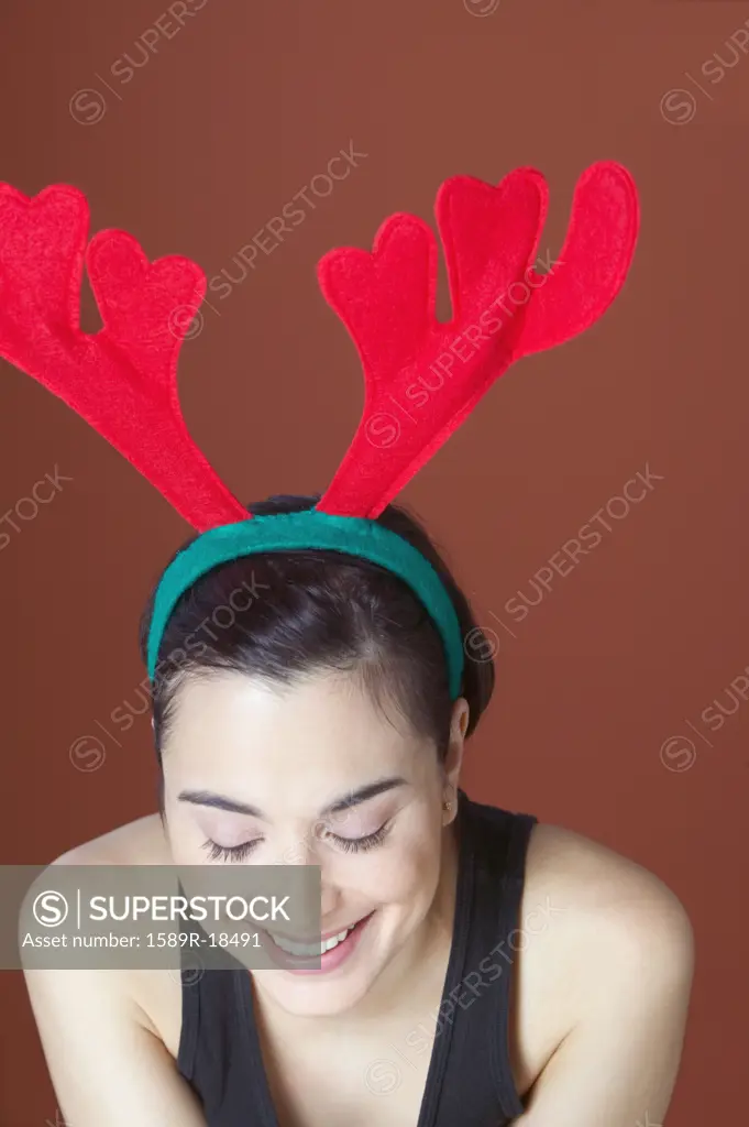 Woman wearing felt antlers looking down