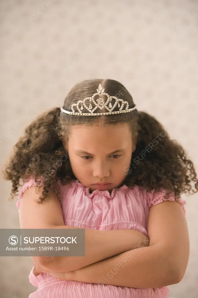 Young girl pouting with princess crown