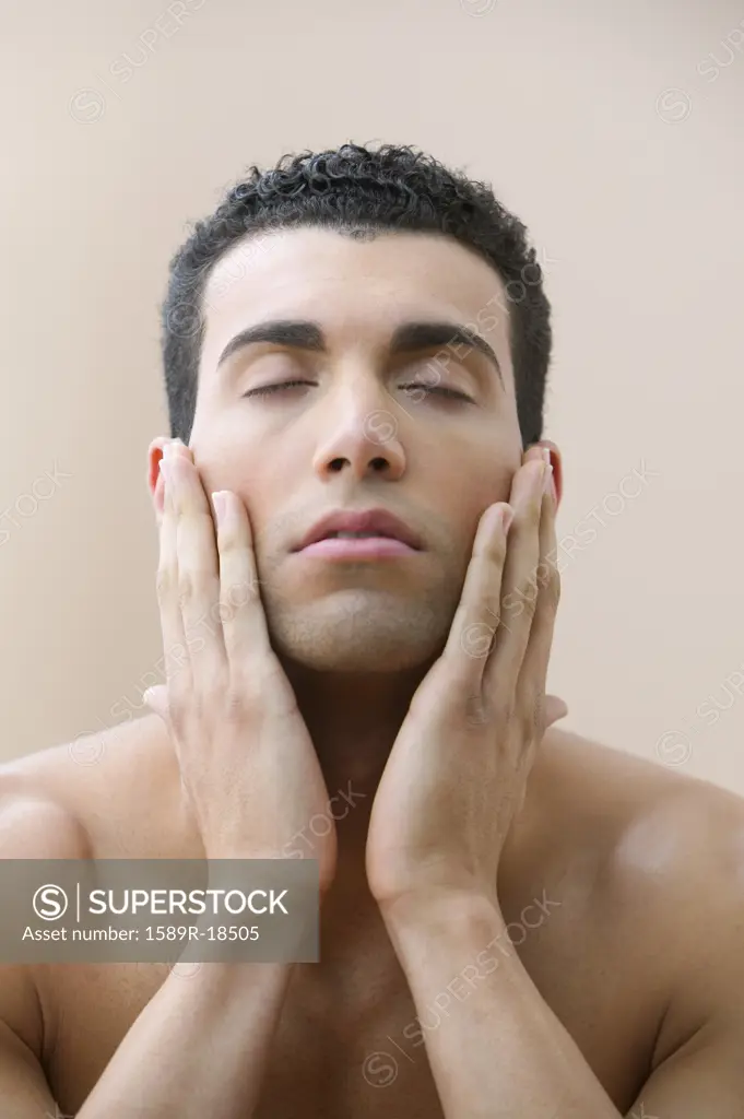 Man with eyes closed and hands on face
