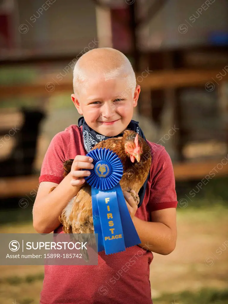 Caucasian boy with prize winning chicken on farm