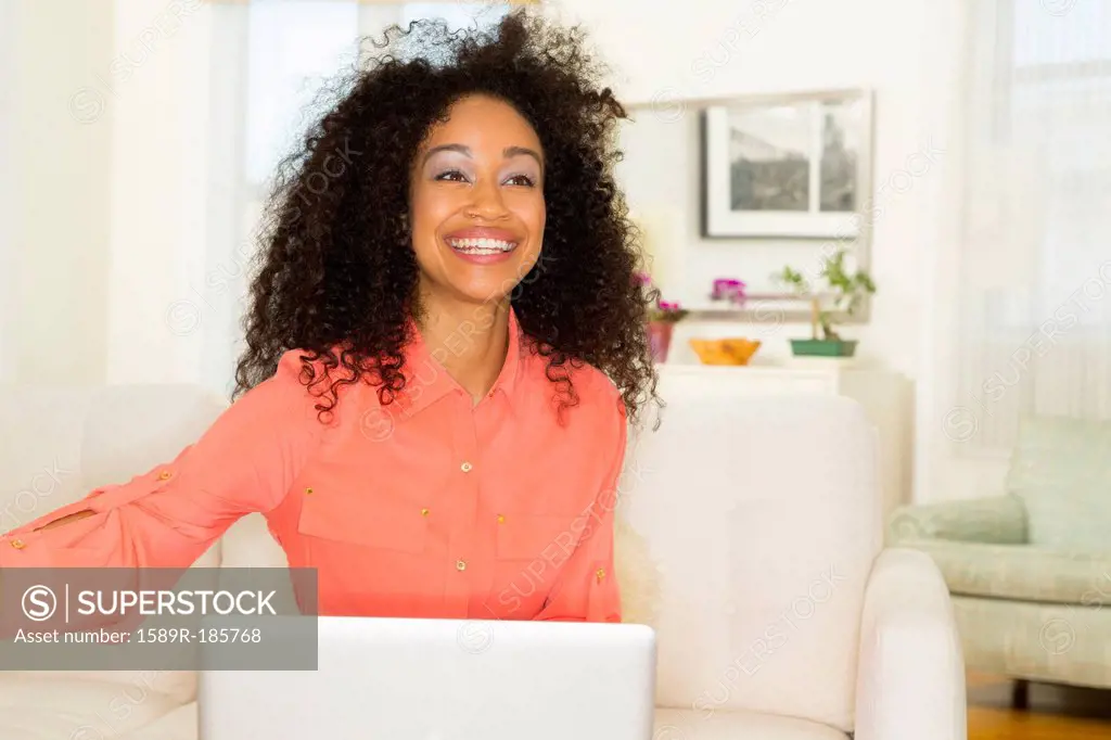 Mixed race woman smiling in living room