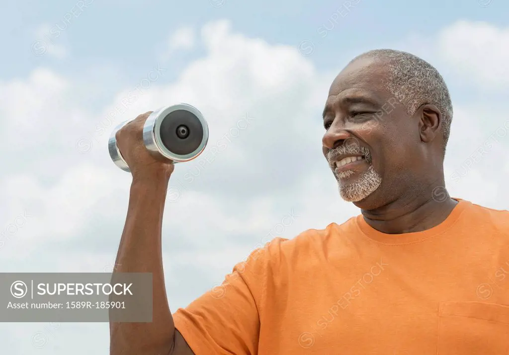 Black man lifting weights outdoors