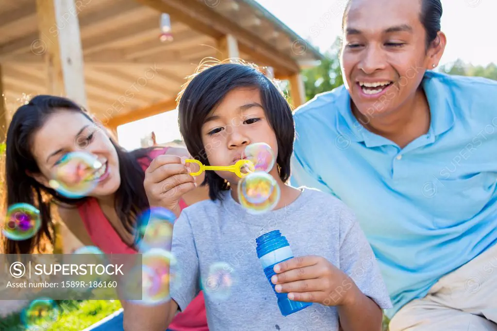 Family blowing bubbles outdoors