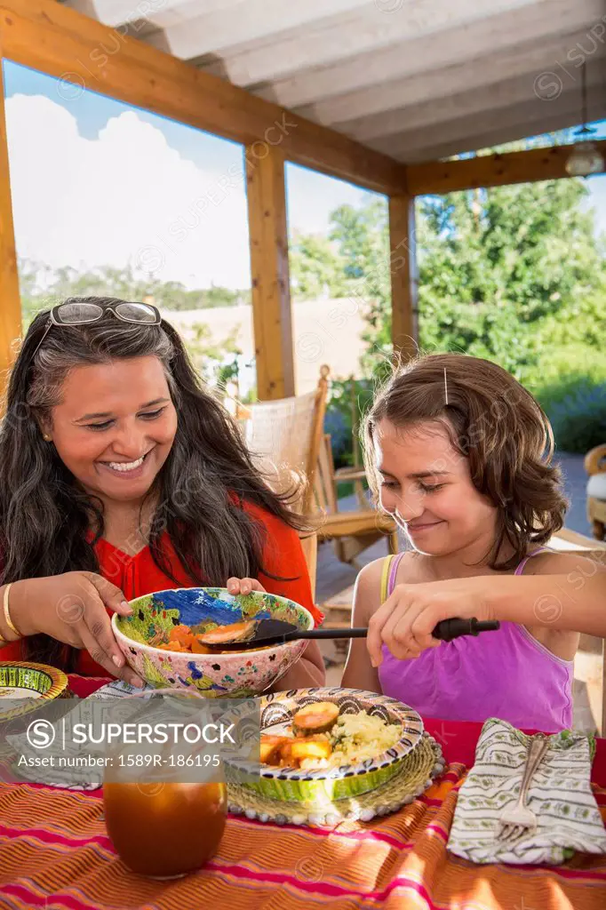 Mother and daughter eating at table