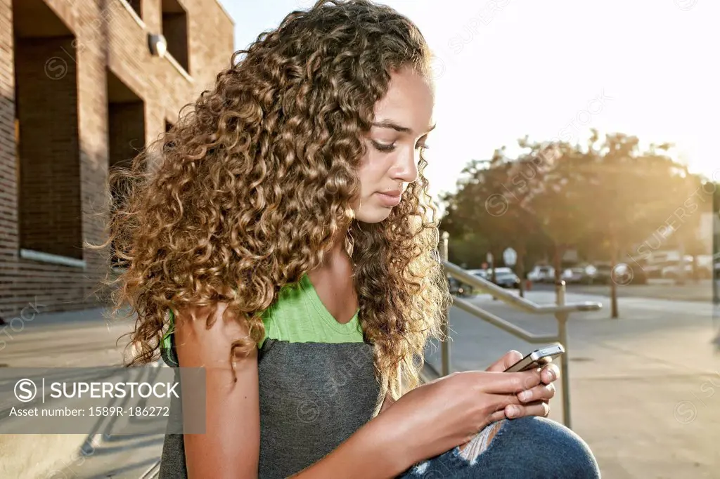 Mixed race girl using cell phone
