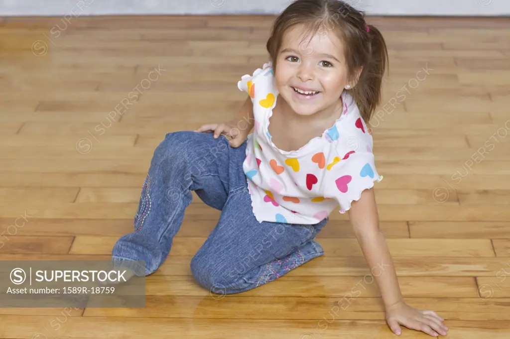 Portrait of young girl kneeling on floor