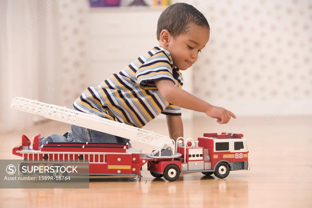 Young boy playing with fire truck
