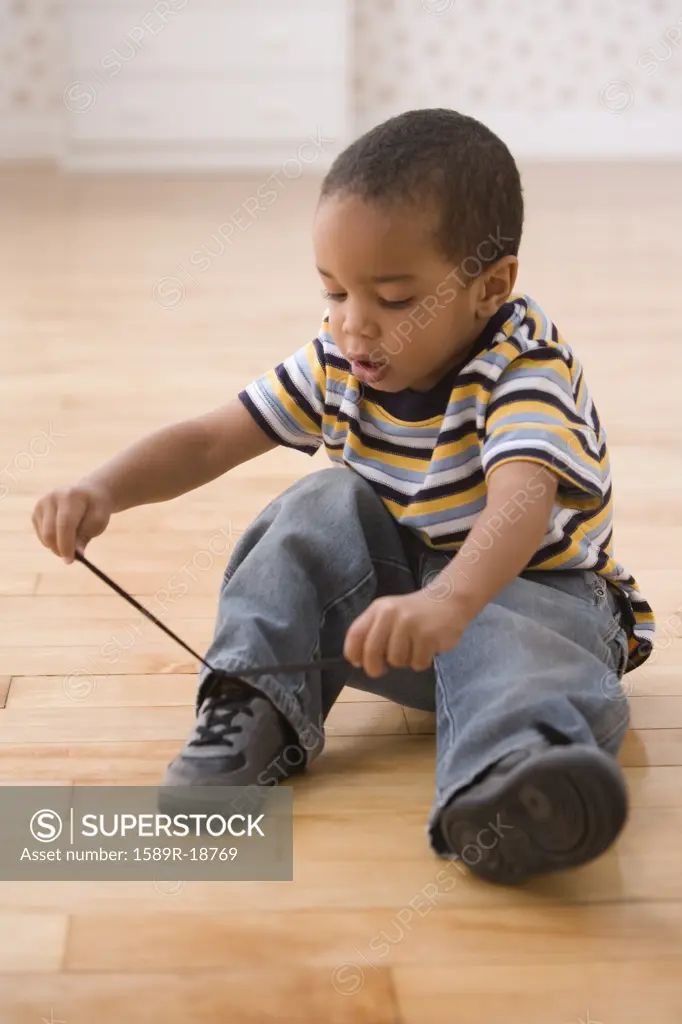 Young boy tying shoe