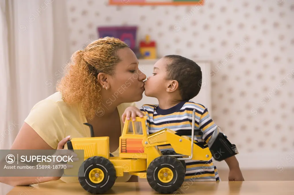 Profile of mother kissing son