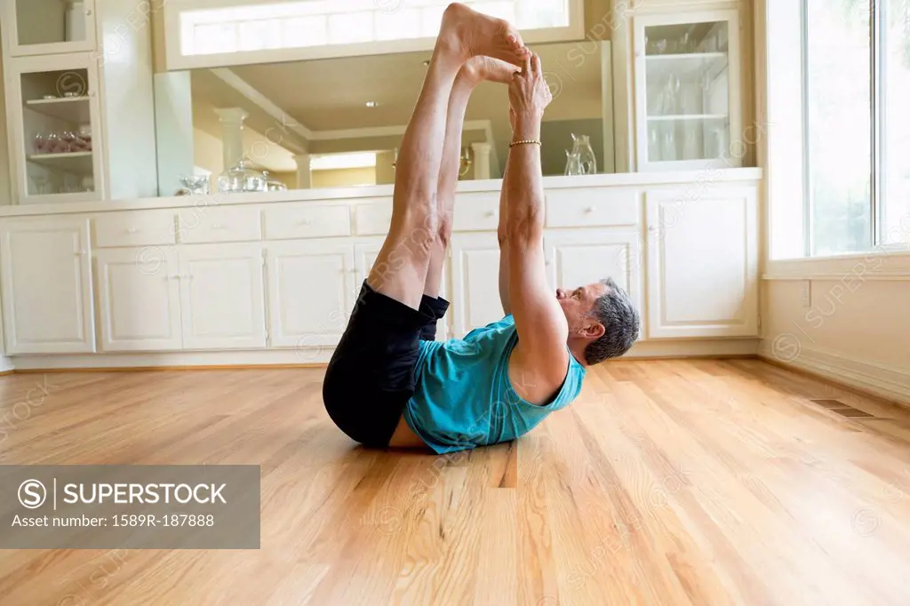 Caucasian man stretching in home